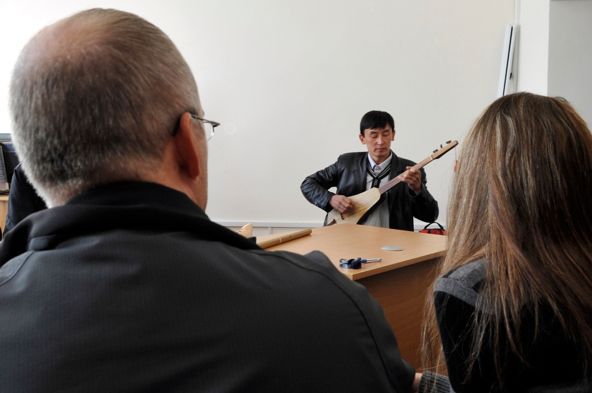 Janar Abdrazakov plays a Kyrgyz traditional guitar called a Komuz for members of the U.S. Air Forces Central Band "Top Flight" during a visit to the American Corner Sept. 27, 2012 in Naryn Province, Kyrgyzstan. Abdrazakov is a local music teacher in Naryn and was a guest for a music exchange with the members of the AFCENT band. The members of Top Flight were on a four-day U.S. Embassy led tour in the Naryn Province where they played for various audiences and conducted music exchanges with local students and staff. (U.S. Air Force photo/Master Sgt. Jason Vaught)