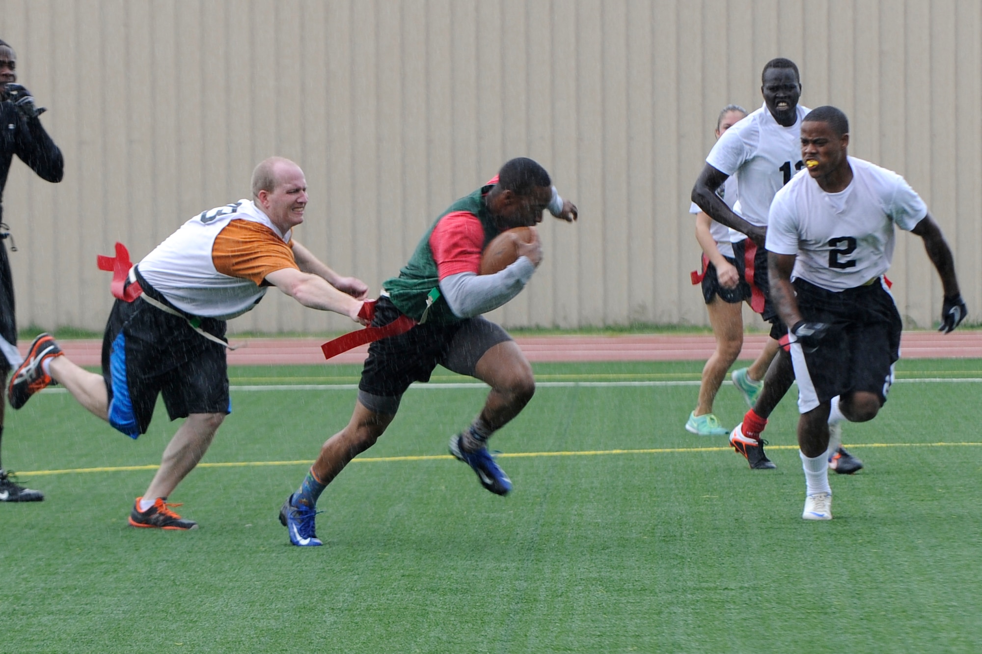 A member of the 8th Fighter Wing, Kunsan Air Base, Republic of Korea runs the ball down field as members of the 51st Fighter Wing, Osan AB, ROK try to strip the flag from him during a peninsula-wide sports day at Osan, Sept. 28, 2012. Although the game was close, Osan captured the championship for football. (U.S. Air Force photo/Senior Airman Marcus Morris)