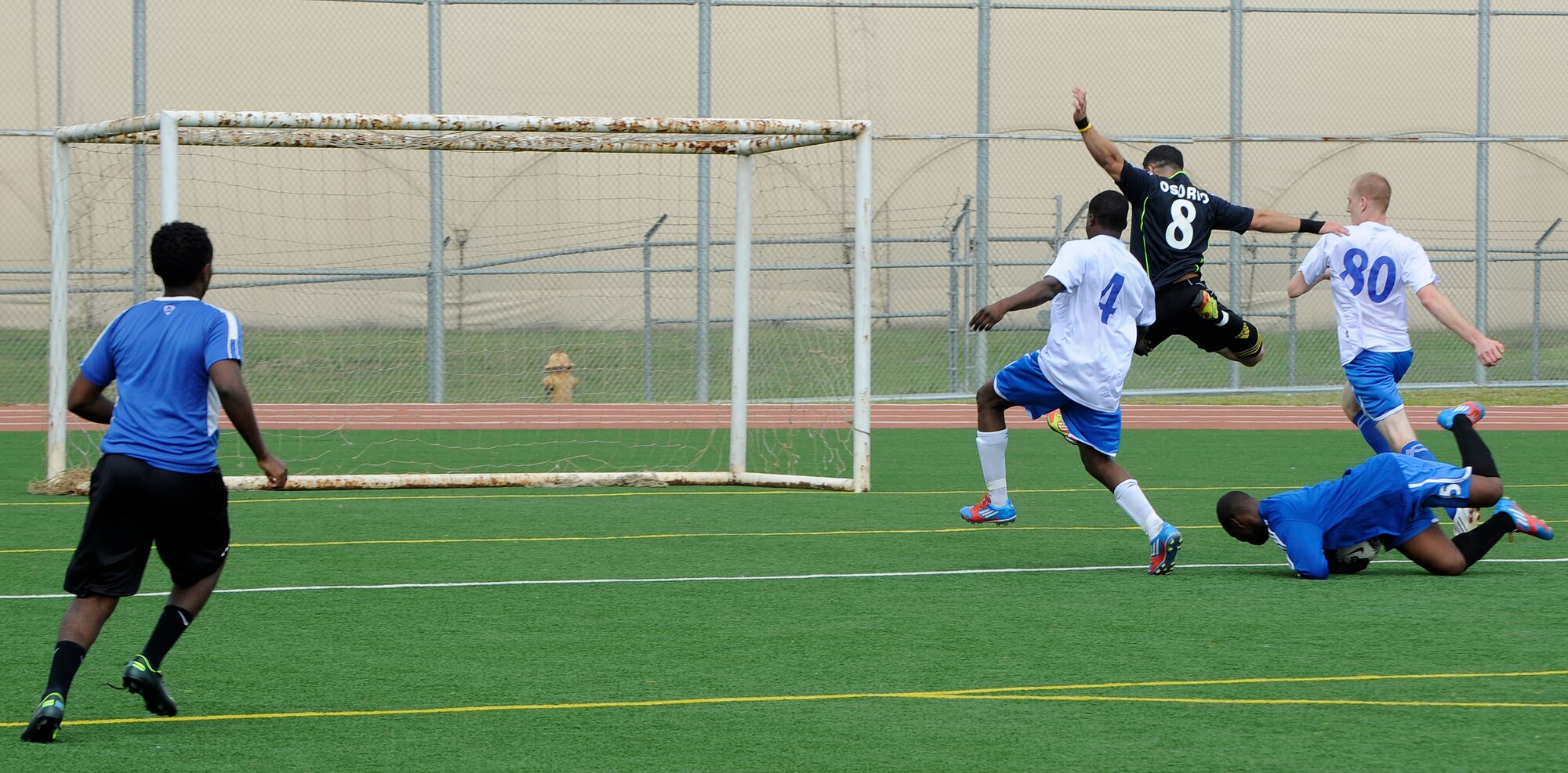 Staff Sgt. James Dixon, 8th Maintenance Squadron, Kunsan Air Base, Republic of Korea, dives on the ball as a member from 51st Fighter Wing, Osan Air Base, ROK, leaps over him at Osan, Sept. 28, 2012. Osan beat Kunsan 2-0 and proceeded to win the soccer championship during the peninsula-wide sports day. (U.S. Air Force photo/Senior Airman Marcus Morris)