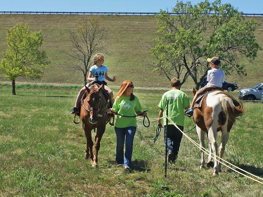 Two children take a hand-led horse ride at the Outdoor Kansas for Kids event held Sept. 8 and 9 at John Redmond Reservoir in southern Kansas. National and local sponsors were encouraged to offer outdoor activities at this annual event to help children learn to appreciate that type of recreation.