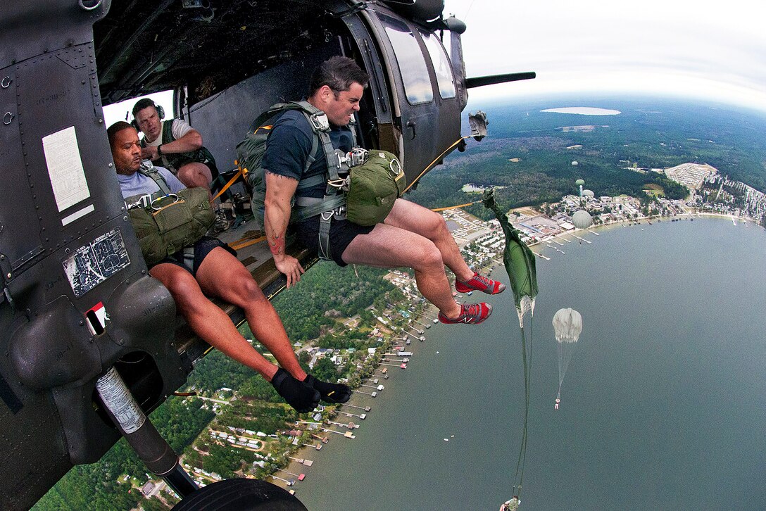 A paratrooper exits a UH-60 Black Hawk helicopter above White Lake near Elizabethtown, N.C., Sept. 19, 2012. The soldiers, assigned to the 82nd Airborne Division's 1st Brigade Combat Team and 95th Civil Affairs Brigade were earning German badges for parachuting.