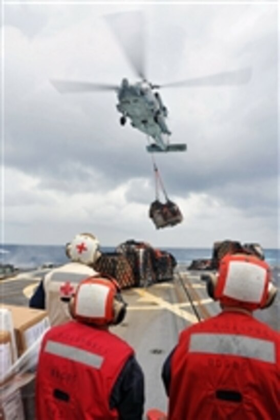 Sailors assigned to the USS McCampbell (DDG 85) stand-by as an MH-60S Seahawk helicopter delivers cargo during a vertical replenishment at sea while the ship operates in the Pacific Ocean on Oct. 2, 2012.  McCampbell is part of the George Washington Carrier Strike Group and is conducting a routine Western Pacific patrol. 