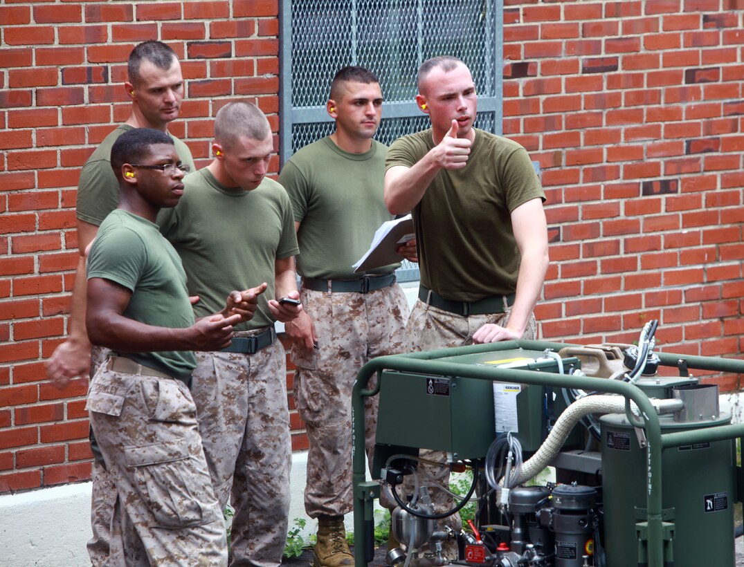 Marines with 2nd Marine Logistics Group start the new joint service transportable decontamination system, or M26, during a training exercise aboard Camp Lejeune, N.C., Oct. 3, 2012. Servicemembers were graded by chemical, biological, radiological, nuclear defense specialists during a practical application portion of the class in order to receive certification for using the M26.