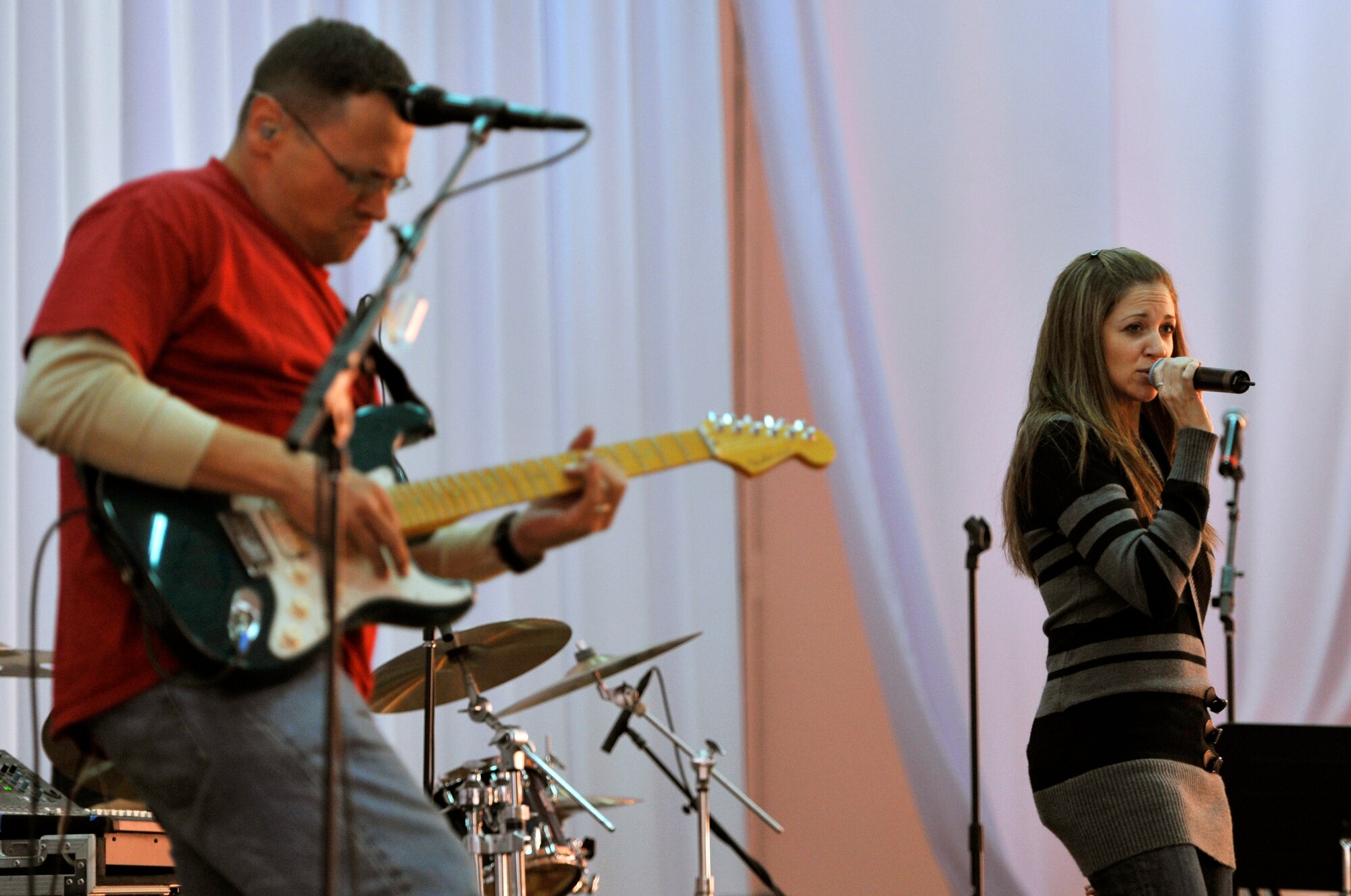 Tech. Sgt. Christin Foley (right) sings while Staff Sgt. Gregory Lacy plays the guitar during a U.S. Air Forces Central band "Top Flight" performance Sept. 27, 2012 at the House of Youth, Naryn Province, Kyrgyzstan. Foley who is Top Flight's lead vocalist and Lacy, the lead guitarist are deployed from Joint Base San Antonio, Texas. The two are natives of Cleveland and Houston respectively. The band performed for more than 800 Kyrgyz residents while on a four-day U.S. Embassy led tour of Naryn. (U.S. Air Force photo/Master Sgt. Jason Vaught)