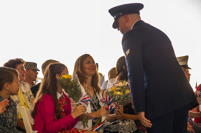 Tina Hartford receives a bouquet of flowers welcoming her to Joint Base Charleston – Air Base during the 437th Airlift Wing change of command ceremony Oct. 5, 2012, in Nose Dock 2 at JB Charleston - Air Base, S.C. Hartford is the wife of Col. Darren Hartford, the new 437th AW commander. (U.S. Air Force photo/Airman 1st Class George Goslin)
