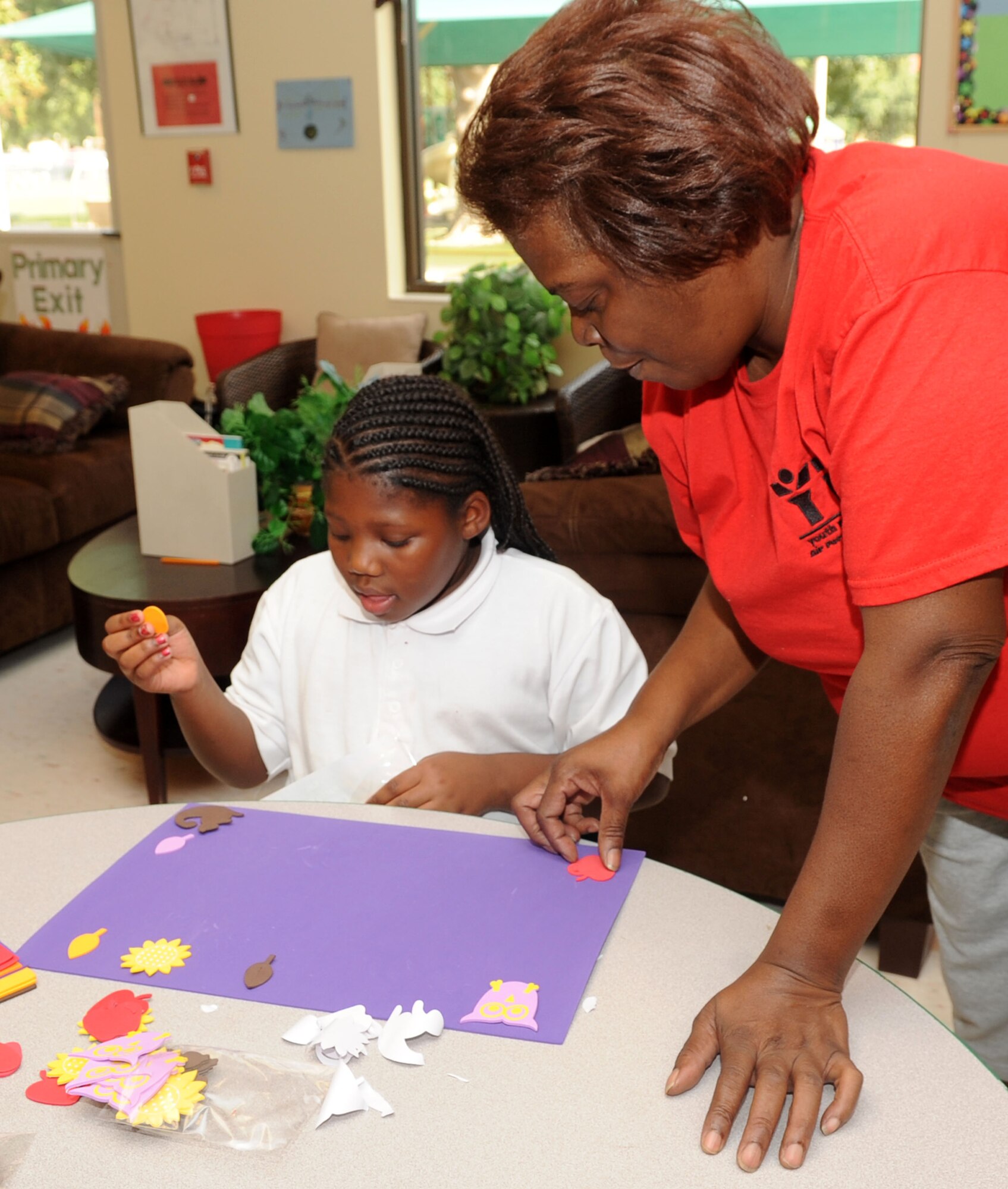 Aamiyah Lamb, 8, daughter of Staff Sgt. Clifford Lamb, 2nd Maintenance Squadron, makes a place mat with Vanessa Collins, 2nd Force Support Squadron child and youth program assistant, at the Youth Center on Barksdale Air Force Base, La., Oct. 5. School-age children in the Give Parents a Break program will be able to create various crafts, play in the gym, use computers and even learn to cook throughout their visit. The program helps give active-duty Air Force parents a break from parenting due to unique stressors occurring in their lives. (U.S. Air Force photo/ Senior Airman Kristin High)(RELEASED)
