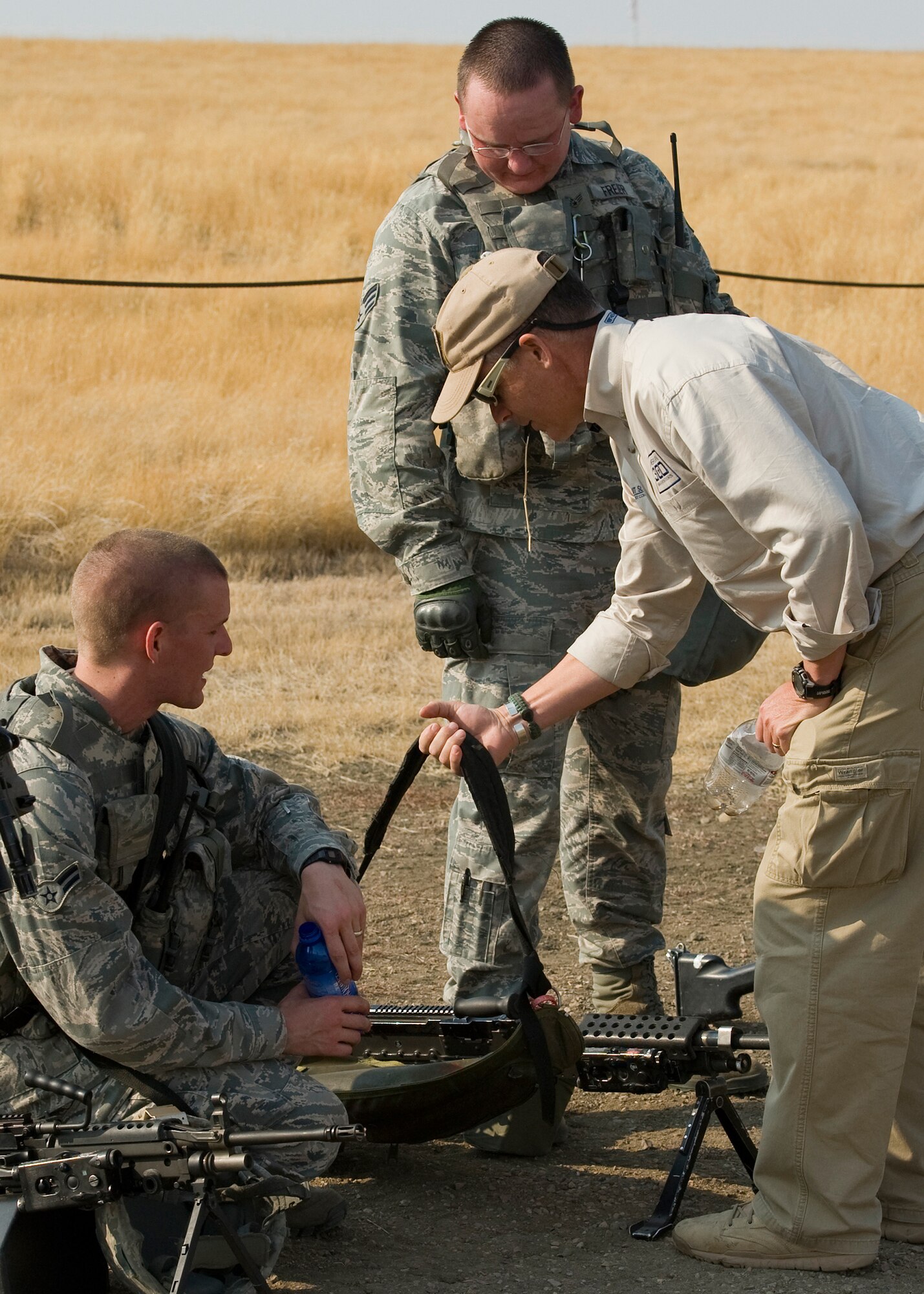 Robi Powers, American300 Warrior Tours founder, asks Airman 1st Class Samuel Frei, left, and Senior Airman Russell Freier, both 341st Missile Security Forces Squadron members, about one of their weapons after observing a Weapons Storage Area recapture exercise Sept. 26. (U.S. Air Force photo/Beau Wade)