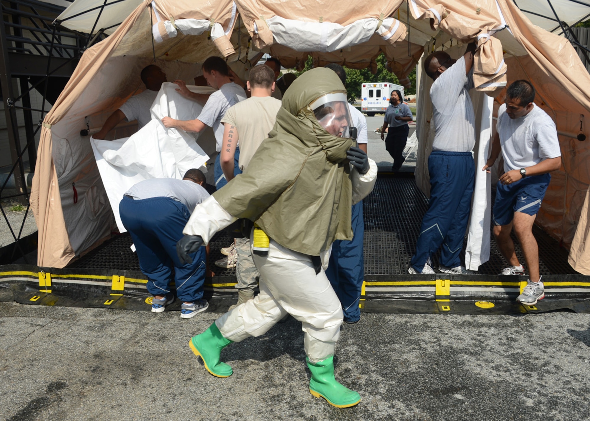 Senior Airman Laura Squires of the 436th Medical Group runs to accomplish a task while members of the 436th MDG patient decontamination team build a de-con tent Sept. 27, 2012, at Dover Air Force Base, Del. Members of the 436th MDG patient decontamination team received hands-on training on In-Place Patient Decontamination procedures. The IPPD is used at the medical treatment facility to decontaminate casualties and responders. (U.S. Air Force photo by Tech. Sgt. Chuck Walker)