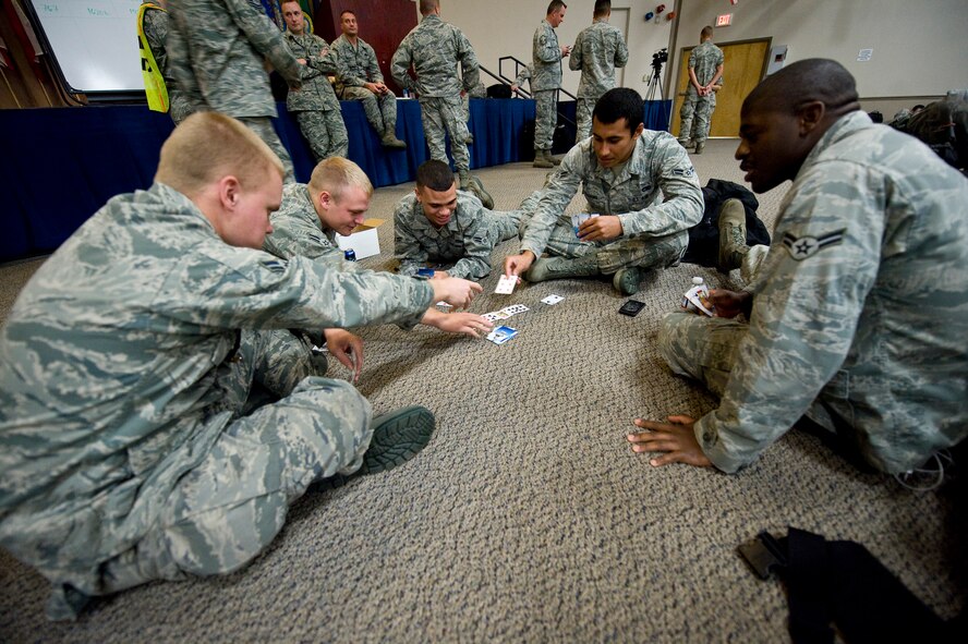 Airmen from the 96th Bomb Squadron play cards while waiting to board their flight to Guam for a deployment from Barksdale Air Force Base, La., Oct 1. The Airmen are deploying for six months in support of the continuous bomber presence in the pacific, a standing Air Force Global Strike Command deterrence mission. (U.S. Air Force photo/Staff Sgt. Chad Warren)(RELEASED)