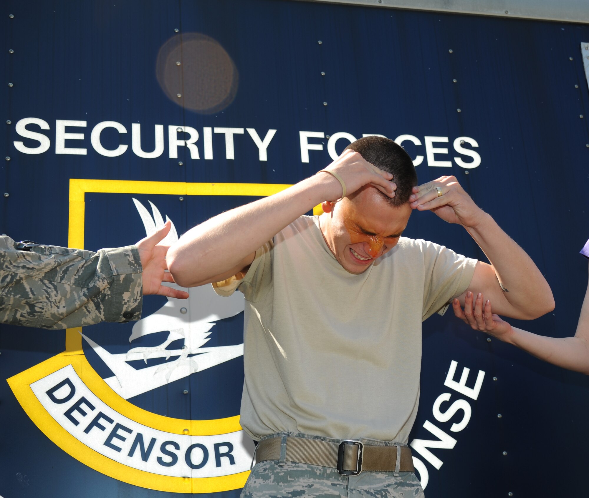 Senior Airman Brian Heiney, 81st Security Forces Squadron, reacts after being exposed with oleoresin capsaicin spray during OC spray training Sept. 3, 2012, at Keesler Air Force Base, Miss.  The training is a required one-time exposure of the OC spray for all Security Forces members.  (U.S. Air Force photo by Kemberly Groue)