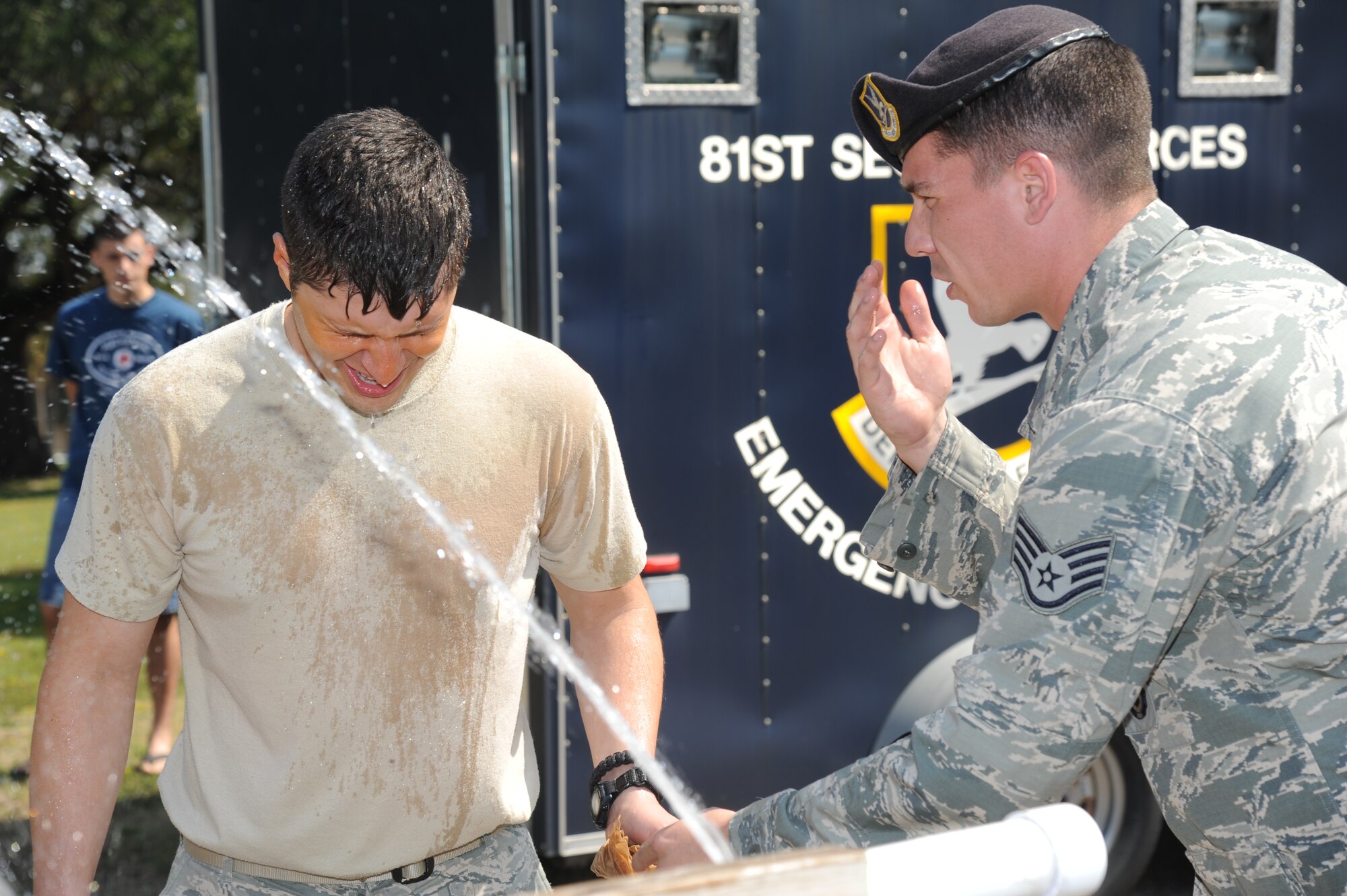 Capt. Chris Porta, 81st Security Forces Squadron operations officer, is assisted by Staff Sgt. Hayden Granger, 81st SFS, with washing his eyes out after being sprayed with oleoresin capsaicin during OC spray training Sept. 3, 2012, at Keesler Air Force Base, Miss.  The training is a required one-time exposure of the OC spray for all Security Forces members.  (U.S. Air Force photo by Kemberly Groue)