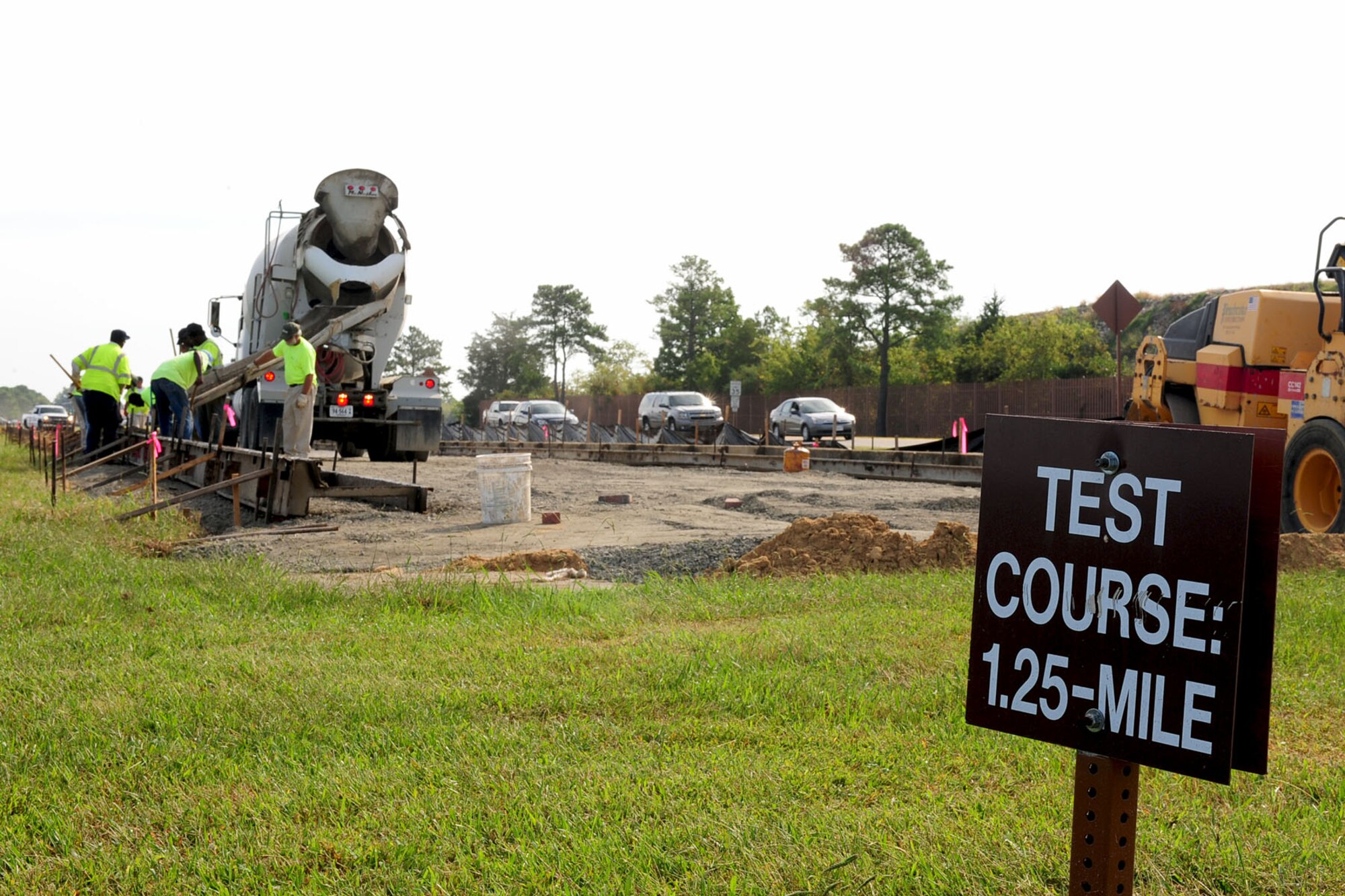 Civilian contractors lay concrete at Langley Air Force Base, Va., Oct. 5, 2012. A turning point of the new extension of Lee Road will be at the 1.25-mile physical-training test marker. (U.S. Air Force photo by Staff Sgt. Ashley Hawkins/Released)