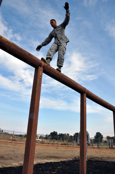 Senior Airman Oscar Gomez, 90th Security Forces Group Tactical Response Force, balances across a high beam during the security forces obstacle course competition at Camp Guernsey, Wyo. for the Air Force Global Strike Command’s Global Strike Challenge Sept. 27. (U.S. Air Force photo by Senior Airman Dan Gage)