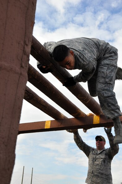 Senior Airman Oscar Gomez, 90th Security Forces Group Tactical Response Force, flips over the last log of the “Belly Buster” as he dismounts the obstacle while Staff Sgt. Wallace Litzinger, 620th Ground Combat Training Squadron, resets the logs for the next competitor during the security forces obstacle course competition at Camp Guernsey, Wyo. for the Air Force Global Strike Command’s Global Strike Challenge Sept. 27. (U.S. Air Force photo by Senior Airman Dan Gage)