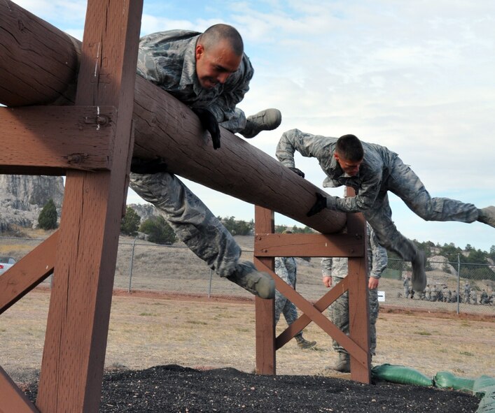 Staff Sgt. Andrew Vautrin, 90th Security Forces Squadron, and Airman 1st Class Colton Schoenegge, 90th Security Forces Group Tactical Response Force, cross over a beam during the security forces obstacle course competition at Camp Guernsey, Wyo. for the Air Force Global Strike Command’s Global Strike Challenge Sept. 27. (U.S. Air Force photo by Senior Airman Dan Gage)
