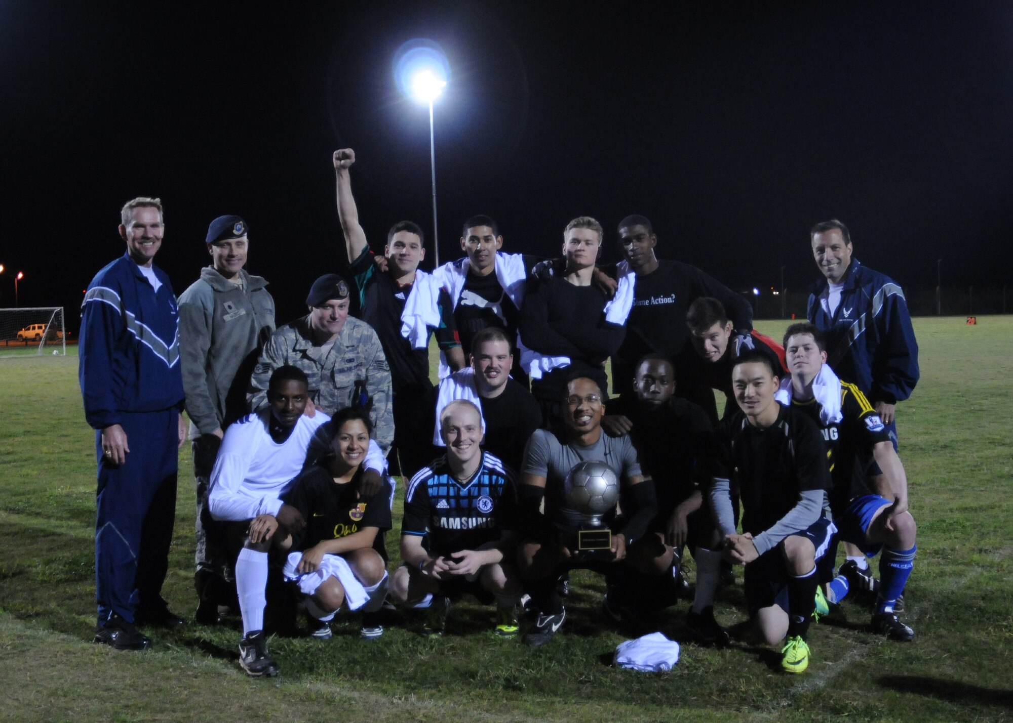 From right, Col. Christopher Kulas, 100th Air Refueling Wing commander, members of the 100th Security Forces Squadron’s intramural soccer team, Lt. Col. David Harris, 100th SFS commander, and Chief Master Sgt. Christopher Powell, 100th ARW command chief, pose for a photo following the Team Mildenhall intramural soccer championship game Oct. 4, 2012, at RAF Mildenhall, England. 100th SFS played two games in one night against the 100th Civil Engineer Squadron; winning both to claim the trophy. (U.S. Air Force photo by Tech. Sgt. Neal X. Joiner/Released)
