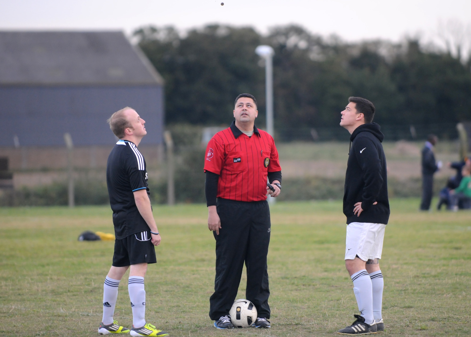 Staff Sgt. Lane Boyt, left, 100th Security Forces Squadron soccer team captain, and Airman 1st Class Vincente Andrade, right, 100th Civil Engineer Squadron team captain, watch the coin toss at the start of the first of two soccer matches Oct. 4, 2012, at RAF Mildenhall, England. The 100th SFS team won both matches and became the Team Mildenhall intramural soccer champions. (U.S. Air Force photo by Tech. Sgt. Neal X. Joiner/Released) 