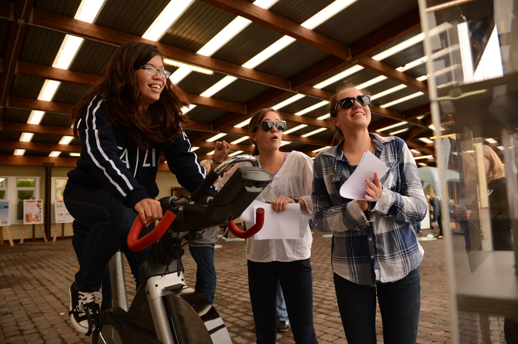 BITBURG ANNEX, Germany – Aiyana Eason pedals on an energy bike as fellow 8th graders Therese and Francesca Gatterburg cheer her on during Energy Day at Bitburg Middle School Oct. 4, 2012. The theme for this month is ‘I am Air Force Energy,’ so students had a chance to burn their own energy with activities. (U.S. Air Force photo by Staff Sgt. Nathanael Callon/Released)