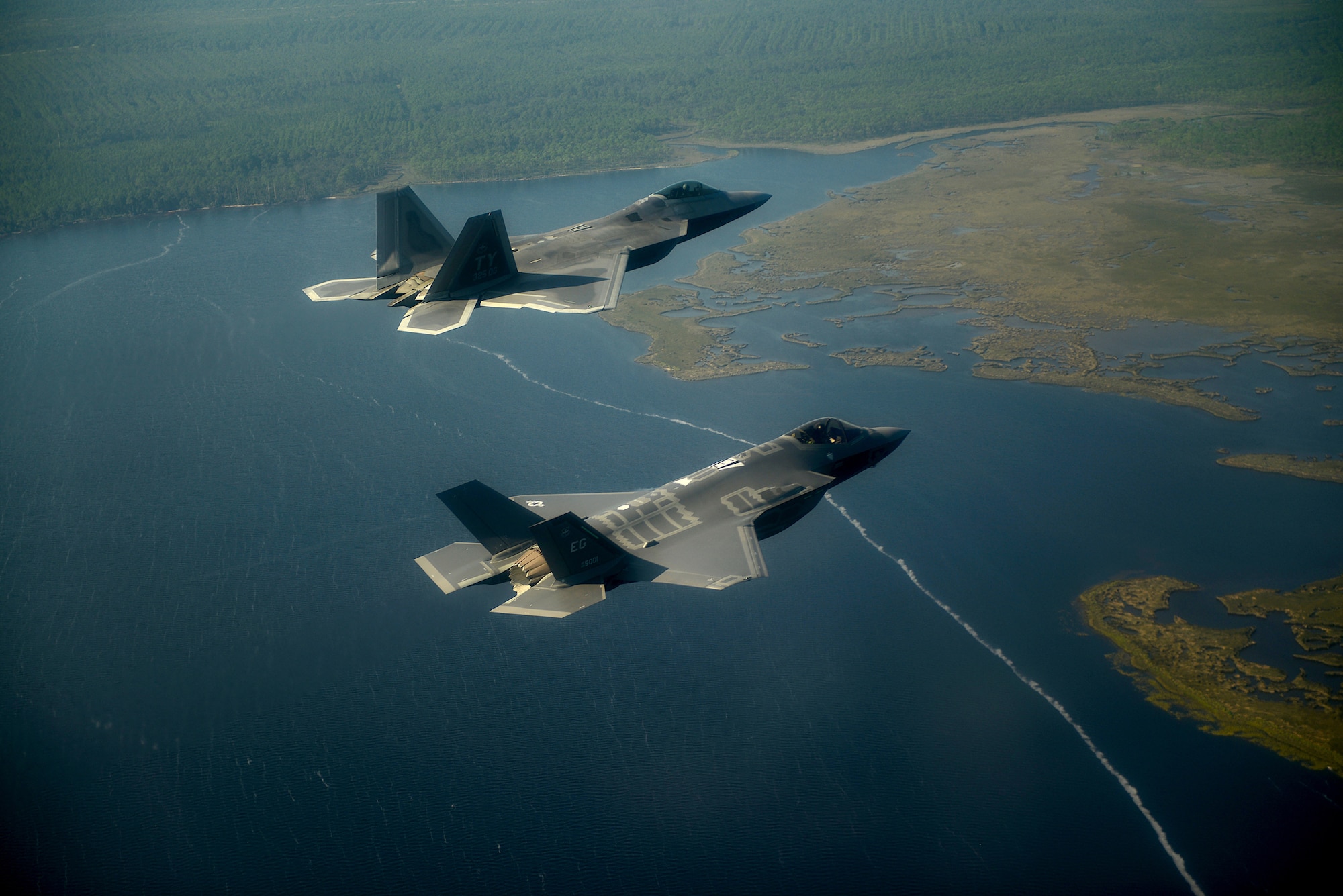 An F-22A Raptor (top) from the 43rd Fighter Squadron at Tyndall Air Force Base, Fla., and an F-35A Lightning II joint strike fighter from the 33rd Fighter Wing at Eglin Air Force Base, Fla., fly over the Emerald coast Sept. 19, 2012. (U.S. Air Force photo/Master Sgt. Jeremy T. Lock)