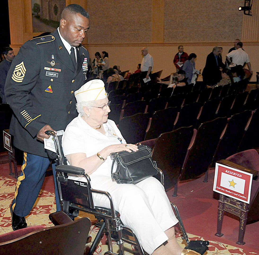 Command Sgt. Maj. Alvin Chaplin Sr., Headquarters, Headquarters Battalion, U.S. Army
North, helps Esther Campbell Gates, a senior Gold Star Mother, out of the theater following
the Survivor Outreach Services ribbon cutting ceremony Sept. 29 at the Joint Base
San Antonio-Fort Sam Houston Theater. (U.S. Army photo by Sgt. 1st Class Christopher DeHart)