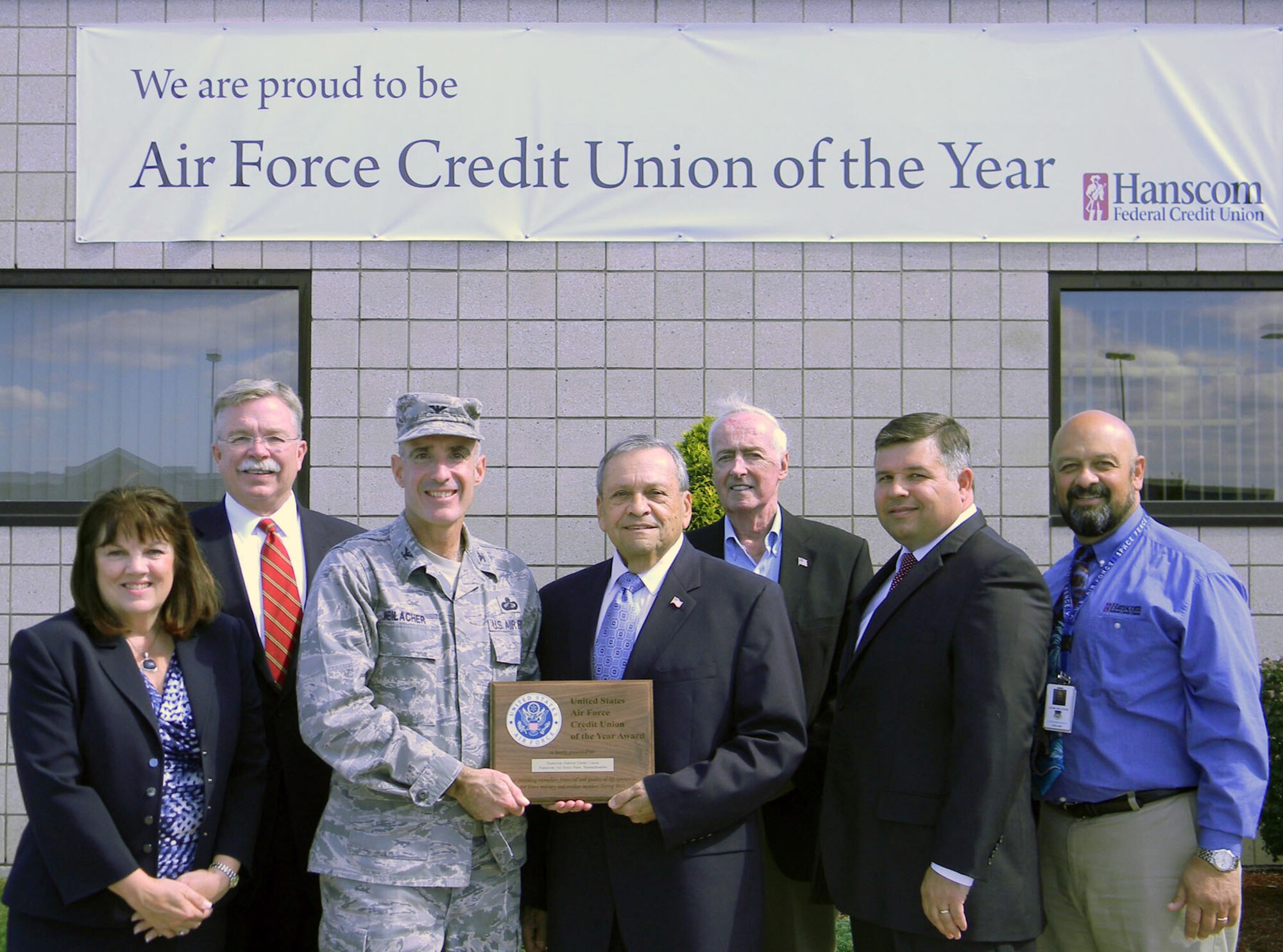 HANSCOM AIR FORCE BASE, Mass. - Col. Lester A Weilacher, 66th Air Base Group commander, presents a plaque recognizing Hanscom Federal Credit Union as Air Force Credit Union of the Year for 2011 to Paul Marotta (center), HFCU chairman of the board, outside of the credit union Sept. 27. Also pictured from left to right are HFCU board member Theresa Conrad, President and CEO David Sprague, board member Frederick Ryan, 66th Air Base Group deputy director Tom Fredericks and board member John Delcore. (Courtesy photo)