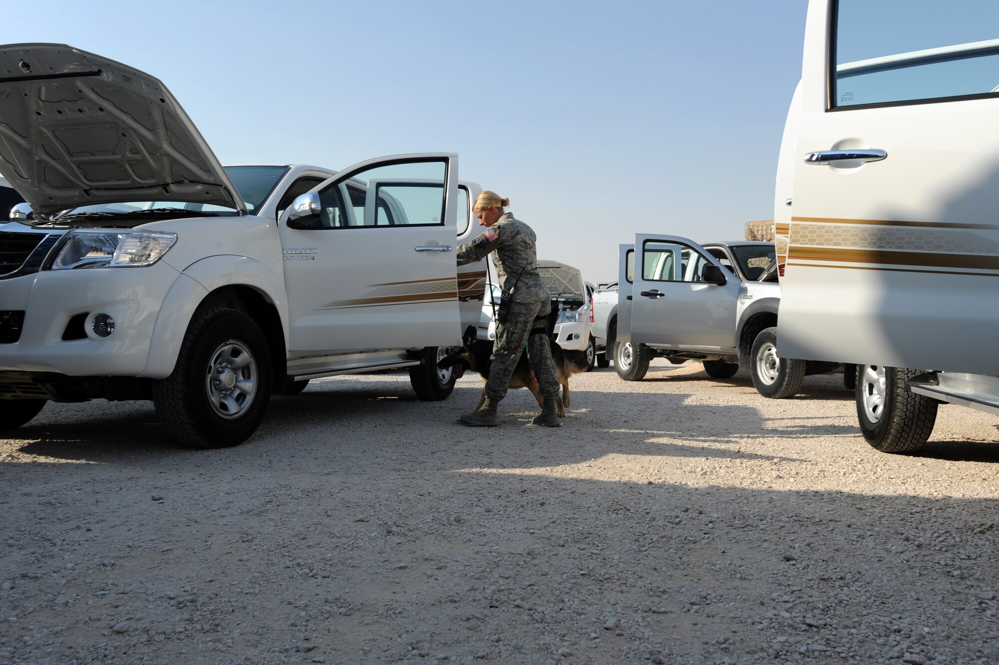 U.S. Air Force Staff Sgt. Bobbie Ohm and military working dog Nero, search a vehicle for prohibited items at the 379th Air Expeditionary Wing, Southwest Asia, October 1, 2012. The canine?s heightened sense of smell makes it a valuable asset in detecting and preventing prohibited items from being brought on the base. (U.S. Air Force photo/Staff Sgt. Sheila deVera) 
