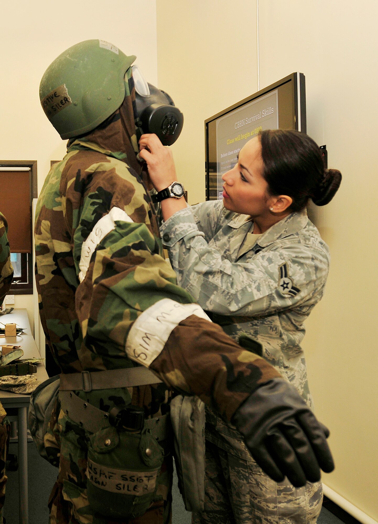 ROYAL AIR FORCE LAKENHEATH, England - Airman 1st Class Vikki Flores, 48th Civil Engineer Squadron emergency management apprentice (right), adjusts the gas mask of a chemical, biological, radiological, nuclear class student at building 1301, Oct. 2, 2012. Flores was nominated for a Liberty Spotlight because she displays the core value of "Excellence in All We Do." (U.S. Air Force photo by Senior Airman Tiffany M. Grigg)