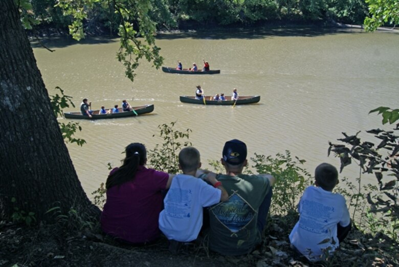 A family sits on ridge at John Redmond Reservoir in southern Kansas watching people canoeing.  The free canoe rides were one of the many activities offered during the Outdoor Kansas for Kids event, Sept. 8 and 9 to provide fun and entertaining events to help give kids a better appreciation of the outdoors.