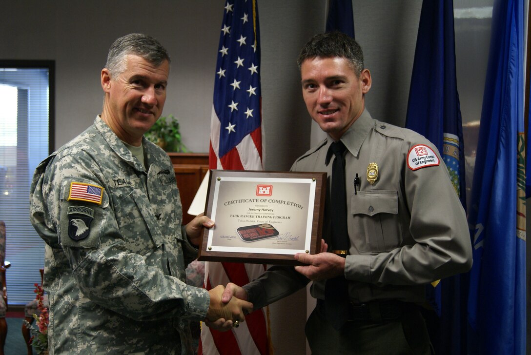 Col. Michael Teague, Tulsa District commander congratulates James Harvey, Lake Texoma park ranger for graduating the park ranger training program. 