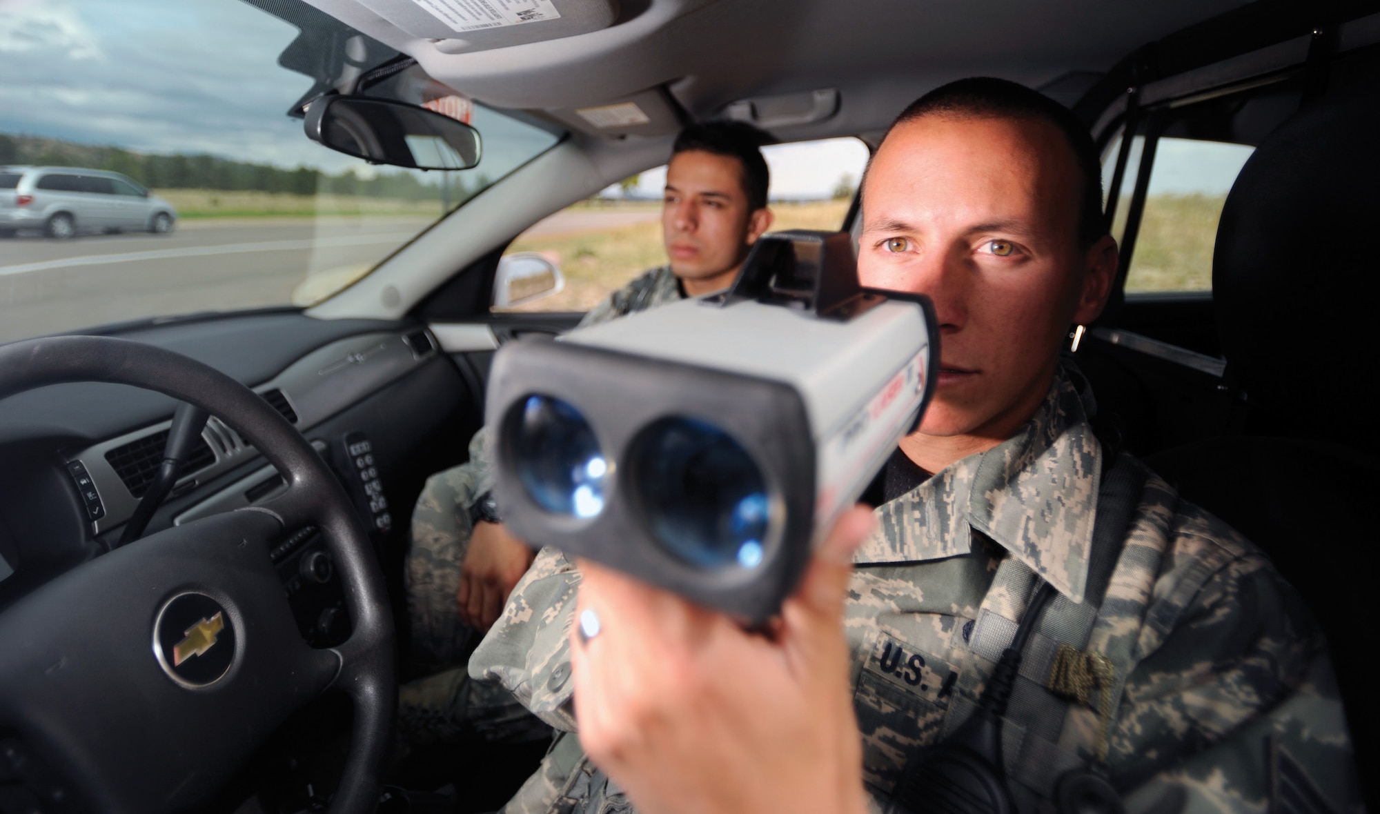 Senior Airman Brandon Aguirre (foreground) and Airman 1st Class Hans Castillo, patrollers with the 10th Security Forces Squadron, monitor drivers on South Gate Boulevard Sept. 26. Getting caught speeding on Academy grounds can be costly. (U.S. Air Force photo/Carol Lawrence)