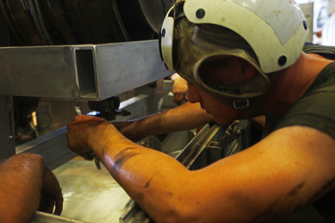 USS IWO JIMA, U.S. 5th Fleet Area of Responsibility (Sept 22, 2012) -Lance Cpl. Matthew Dixon, a native of Mt. Olive, Miss., and flight line mechanic with the airframes section for Marine Medium Tiltrotor Squadron 261 (Reinforced), 24th Marine Expeditionary Unit, conducts engine maintenance on an MV-22B Osprey in the hangar of USS Iwo Jima (LHD 7), Sept 22, 2012. The aviation maintenance crews work around the clock to ensure the 24th MEU's aircraft are always ready to fly in support of the various missions they could be called for. The 24th MEU is deployed with the Iwo Jima Amphibious Ready Group as a theater reserve and crisis response force for U.S. Central Command in the U.S. Navy's 5th Fleet area of responsibility. (U.S. Marine Corps photo by Lance Cpl. Tucker S. Wolf) 