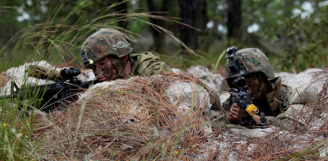 Lance Cpl. Christian Ponte (left), a team leader with Company B, 1st Battalion, 9th Marine Regiment, sights in with Pfc. Victor Levy (right), a basic rifleman, as they prepare for any enemy attacks on their position. Marines from 1/9 set up positions along a gridded area through which simulated enemy troops and vehicles would be trying to escape as part of their training Oct.1-4. 