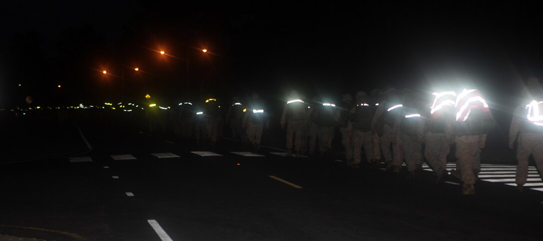 Marines and sailors with Headquarters Battalion, 2nd Marine Division Hike down the road early in the morning, Oct. 3.  The eight-mile conditioning night ended with the Marines setting up camp and spending the night in the field and enjoying a mess night together.