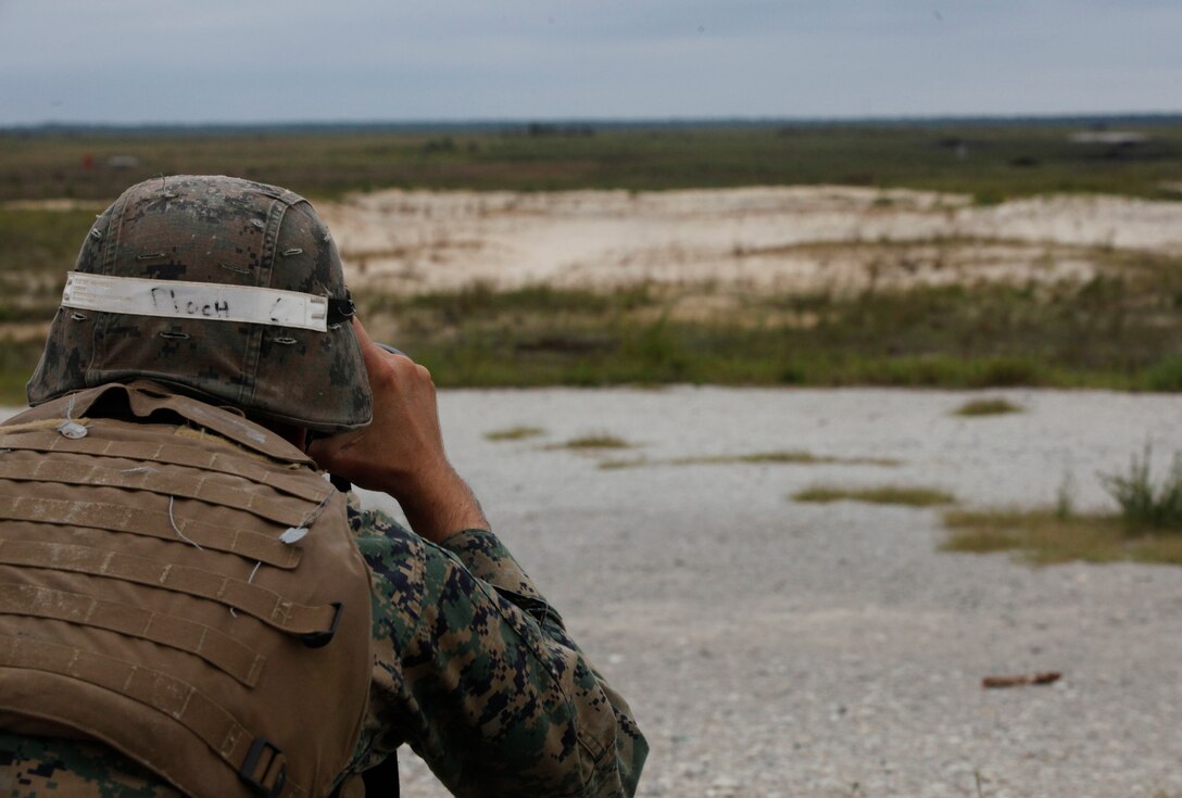 Sgt. Cory C. Ploch, an instructor with Infantry Training Battalion, School of Infantry – East, uses optics to look down range aboard Marine Corps Base Camp Lejeune as a forward observer as part of an instructor-only class on firing from the defilade Sept 19. The class is taught the rare technique of firing from the defilade with a direct-fire M240B machine gun. 