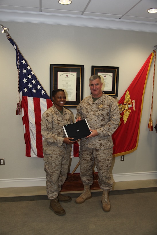 Maj. Gen. Glenn M. Walters, right, the commanding officer of 2nd Marine Aircraft Wing, hands a web book to Lance Cpl. Sha'ron M. Barron, an individual material readiness list manager with Marine Attack Squadron 231 Oct. 3. More than 50 Marines and their families benefited from the donation of web books from Operation Homelink.