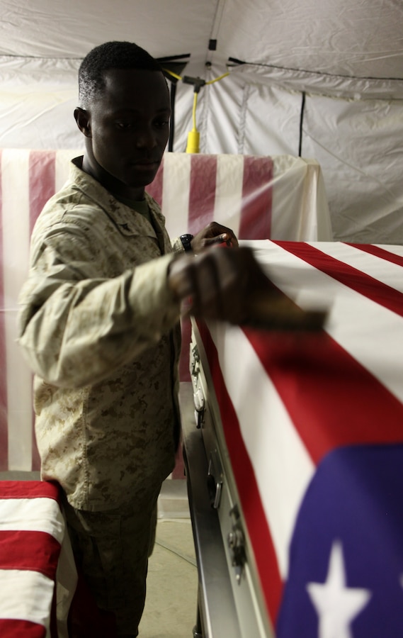 Lance Cpl. Christopher M. Tarnue, from Baltimore, Md., a personnel retrieval and processing specialist with the Personnel Retrieval and Processing Detachment, 2nd Marine Logistics Group (Forward) works on the last details on a transfer case July 13, 2011, aboard Camp Dwyer, Afghanistan. Marines with the Personnel Retrieval and Processing Detachment, 2nd Marine Logistics Group (Forward) at Camp Dwyer, Afghanistan, are on call 24 hours a day, seven days a week to take care their own in Southern Helmand province and bring them home.