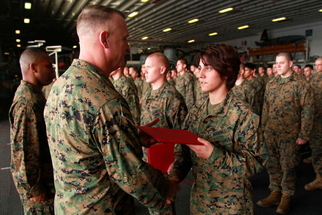 Newly promoted Sgt. Bethany Woloszyn, intelligence analyst, Command Element, 15th Marine Expeditionary Unit, receives her promotion warrant from Col. Scott D. Campbell, the unit’s commanding officer, in the hangar bay of the USS Peleliu, Oct. 1. The 15th MEU is currently embarked as part of the Peleliu Amphibious Ready Group, while they serve as the nation's rapid-response sea-based Marine Air Ground Task Force for Western Pacific Deployment 12-02. Woloszyn, 25, is from Corpus Christi, Texas.