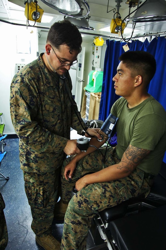 Petty Officer 3rd Class, Adam E. Leat, corpsman, Headquarters and Support Company, Battalion Landing Team 3/5, 15th Marine Expeditionary Unit, measures the blood pressure of Cpl. Anthony S. Banda, a motor transportation operator from the same unit, in the USS Rushmore’s medical department, Oct. 3. Although it’s much smaller than the Peleliu Amphibious Ready Group’s flag ship, the USS Peleliu, the medical and dental departments aboard the Rushmore are capable of preventing and treating illnesses and minor injuries, cleaning teeth and removing cavities, training and educating Marines and sailors and preparing for the rapid treatment of combat casualties. Leat, 25, is from Fresno, Calif., and Banda, 22, is from Yuma, Ariz.