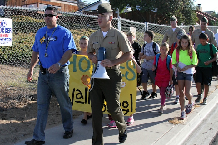 Marines with Headquarters Company, Headquarters and Service Battalion, Marine Corps Recruit Depot San Diego, march with Holmes Elementary School during the National Walk to School Day Oct. 3. The Marines and students of Holmes walked to school from Clairemont Covenant Church located three blocks away. The walk was to promote children and parents to walk to school and spend more time together since most kids get dropped off at school. Local police were there to block off intersections while children, parents and Marines walked to Holmes. 