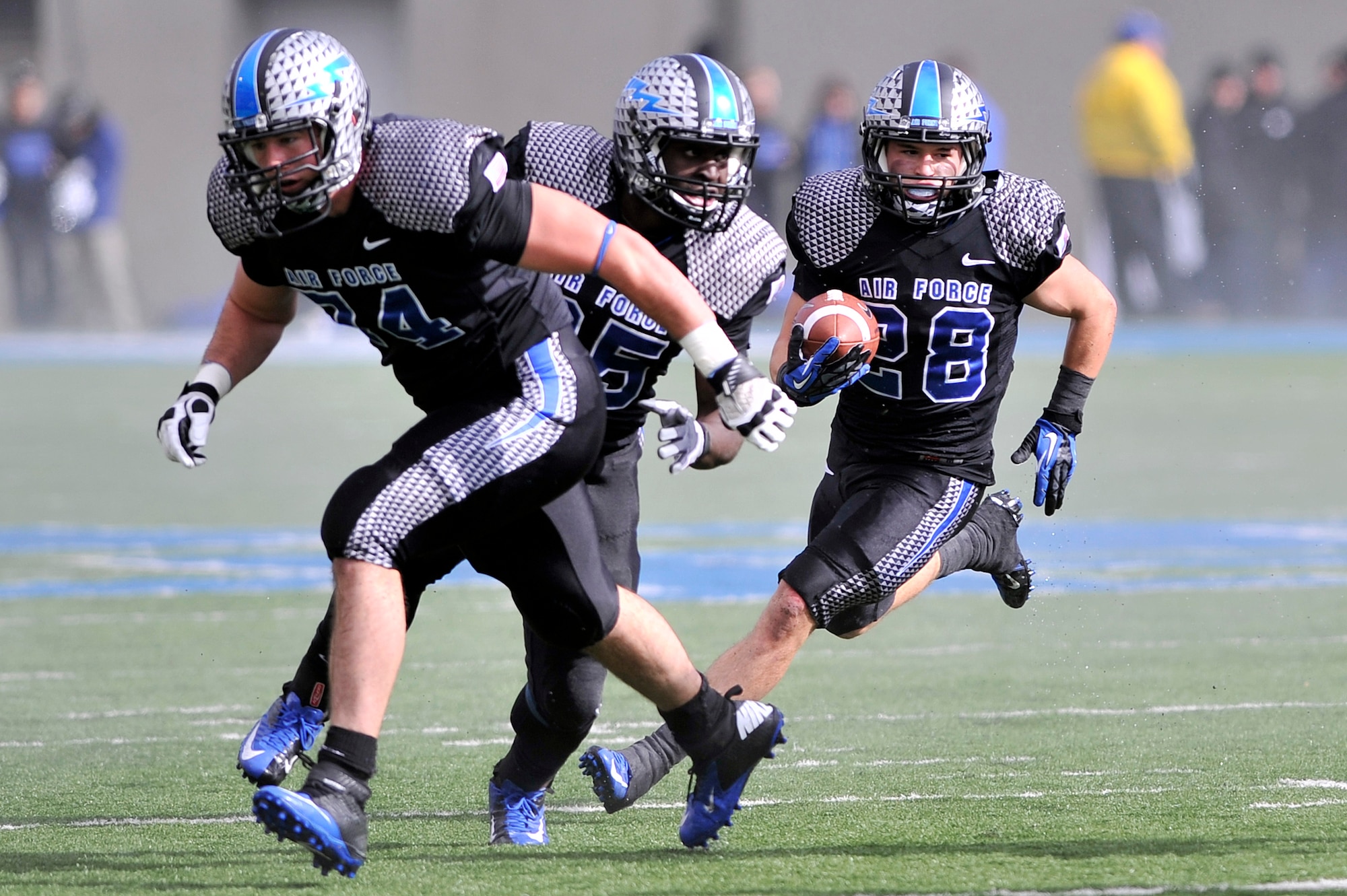 Falcons running back Cody Getz, right, follows his blockers during the Navy-Air Force football game at Falcon Stadium Oct. 6, 2012. Getz had 27 rushes for 206 yards, making him the first player in Air Force history and the second player in Mountain West Conference history with three 200-yard games in one season. (U.S. Air Force photo/Raymond McCoy)