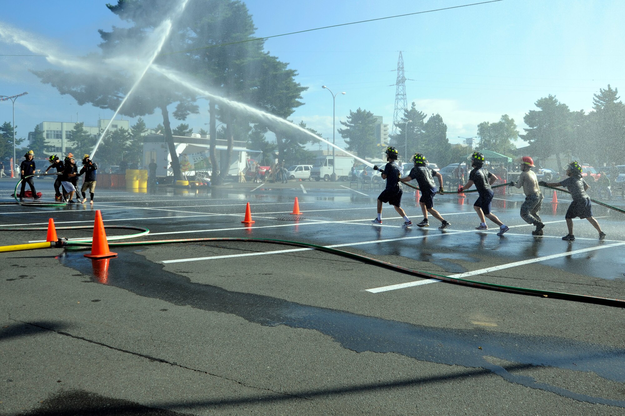 Firefighters from the 35th Civil Engineer Squadron Team A compete against firefighters from Misawa City during the water ball event part of the seventh annual fire muster at Misawa Air Base, Japan, Oct. 7, 2012. Each team aimed water at a ball to push it past a cone on the opponent’s side to win. (U.S. Air Force photo/Tech. Sgt. Marie Brown)