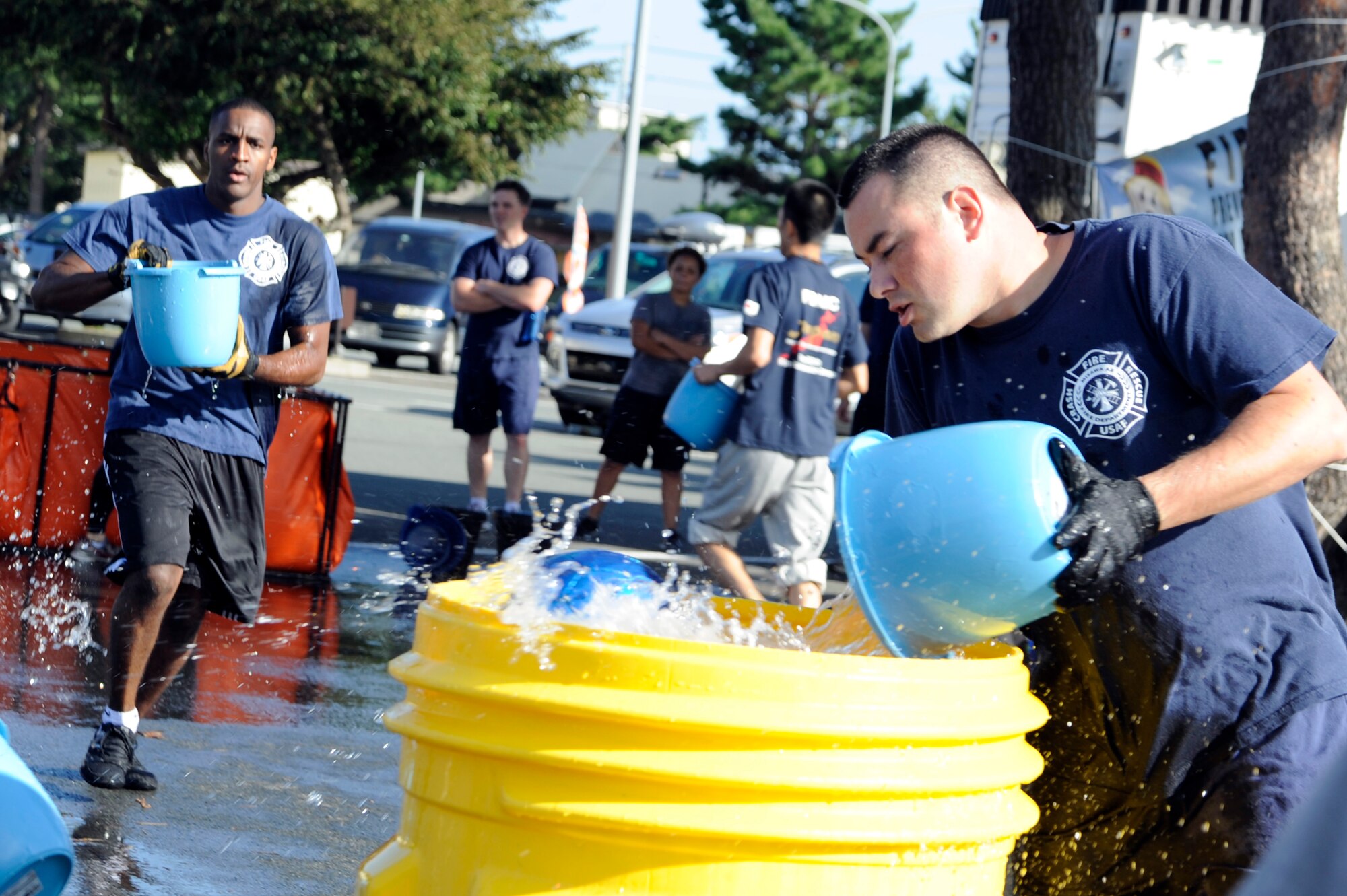 Members of the 35th Civil Engineer Squadron Team B race against the Towada City Fire Department during the bucket brigade event, part of the firefighter combat challenge relay competition, at Misawa Air Base, Japan, Oct. 7, 2012. During the bucket brigade, members of each team had to carry buckets of water to fill their barrel with enough water to knock out the ball and stop the clock. (U.S. Air Force photo/Tech. Sgt. Marie Brown)
