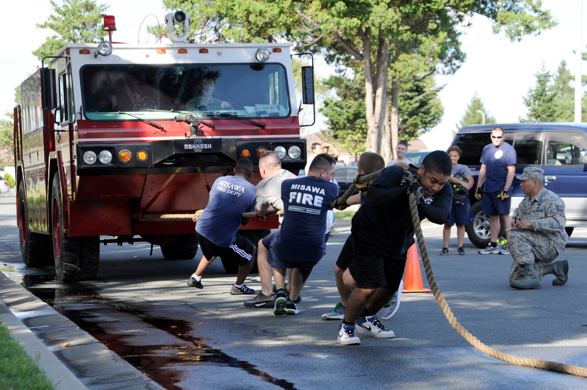 Members of the 35th Civil Engineer Squadron Team B pull a fire truck weighing approximately 22,000 pounds during the firefighter combat challenge relay competition held at The Exchange parking lot on Misawa Air Base, Japan, Oct. 7, 2012. Firefighters from the 35 CES, along with firefighters from Misawa City and Towada City, participated in the seventh annual fire muster to kick off Fire Prevention Week. (U.S. Air Force photo/Tech. Sgt. Marie Brown)