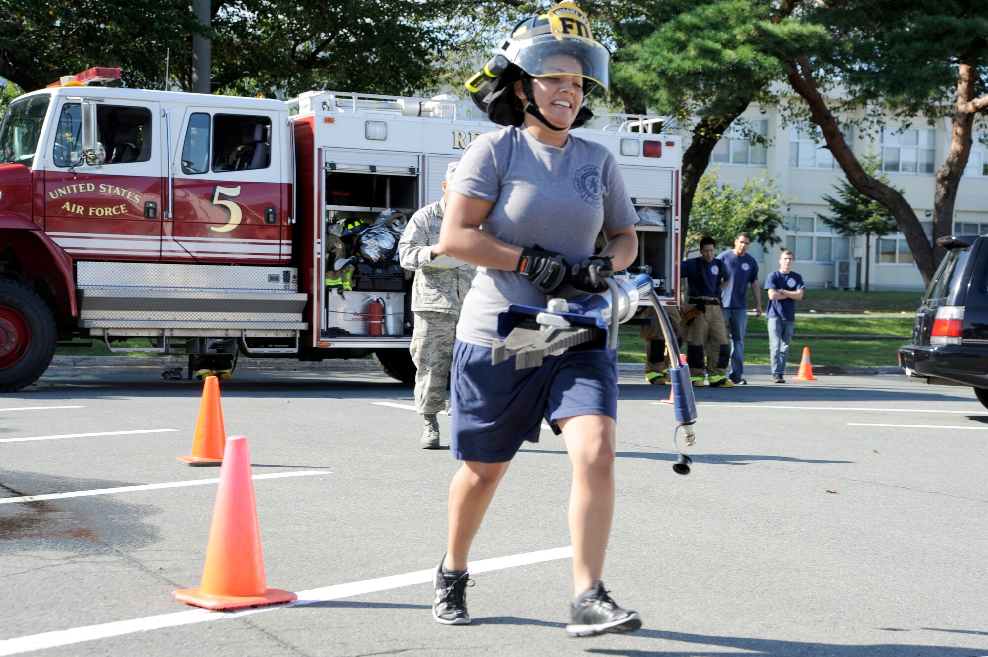 U.S. Air Force Airman 1st Class Hillary Rodriquez, 35th Civil Engineer Squadron Team A member, races through cones during the tool carry event part of the firefighter combat challenge relay, at Misawa Air Base, Japan, Oct. 7, 2012. This is the seventh annual fire muster competition between the Misawa Air Base, Misawa City and Towada City fire departments. (U.S. Air Force photo/Tech. Sgt. Marie Brown)