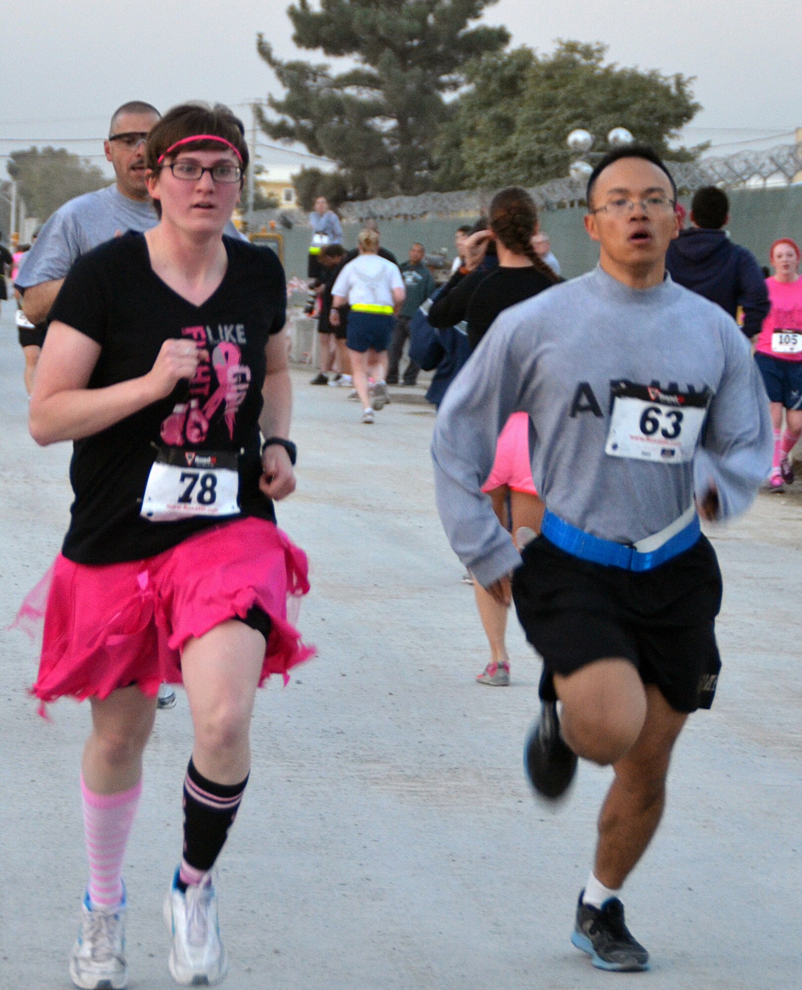 Two Soldiers participate in the 401st Army Field Support Brigade Breast Cancer Awareness Walk/Run Relay at Bagram Airfield, Afghanistan, Oct. 6 2012. The relay was a team event with five members including at least one female per team. More than 700 participants registered in support of breast cancer awareness. Prizes were awarded to the first three teams to finish, and a best “pink costume” team prize. (U.S. Army photo/Summer Barkley/used by permission)