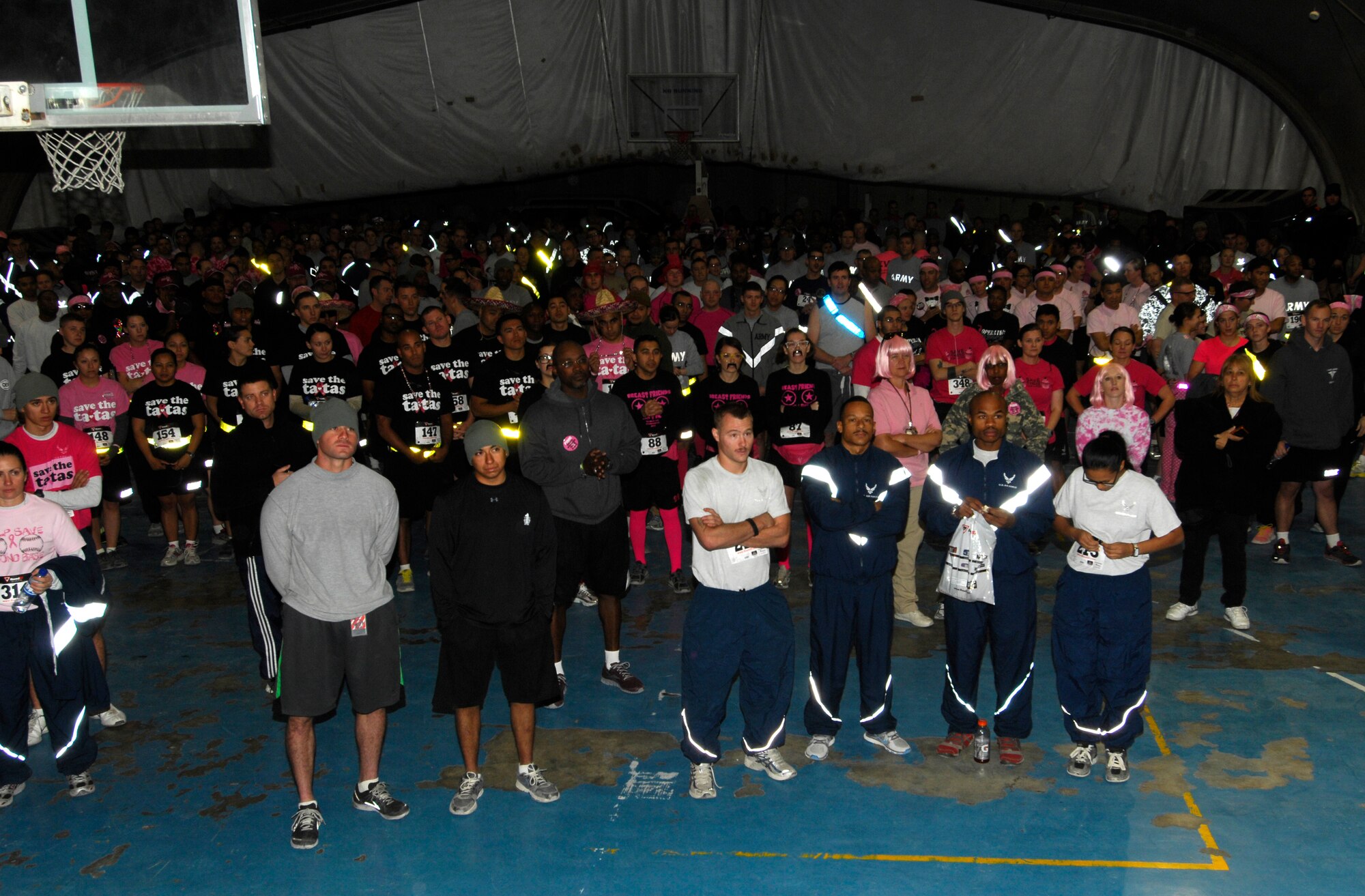 U.S. Servicemembers and civilians listen to a safety briefing before the 401st Army Field Support Brigade Breast Cancer Awareness 8K Walk/Run Relay at Bagram Airfield, Afghanistan, Oct. 6, 2012. The race was a five-member team event, including at least one female per team. More than 700 participants registered in support of breast cancer awareness. Prizes were awarded to the first three teams to finish, and a best “pink costume” team prize. (U.S. Air Force photo/SSgt Jeff Nevison)
