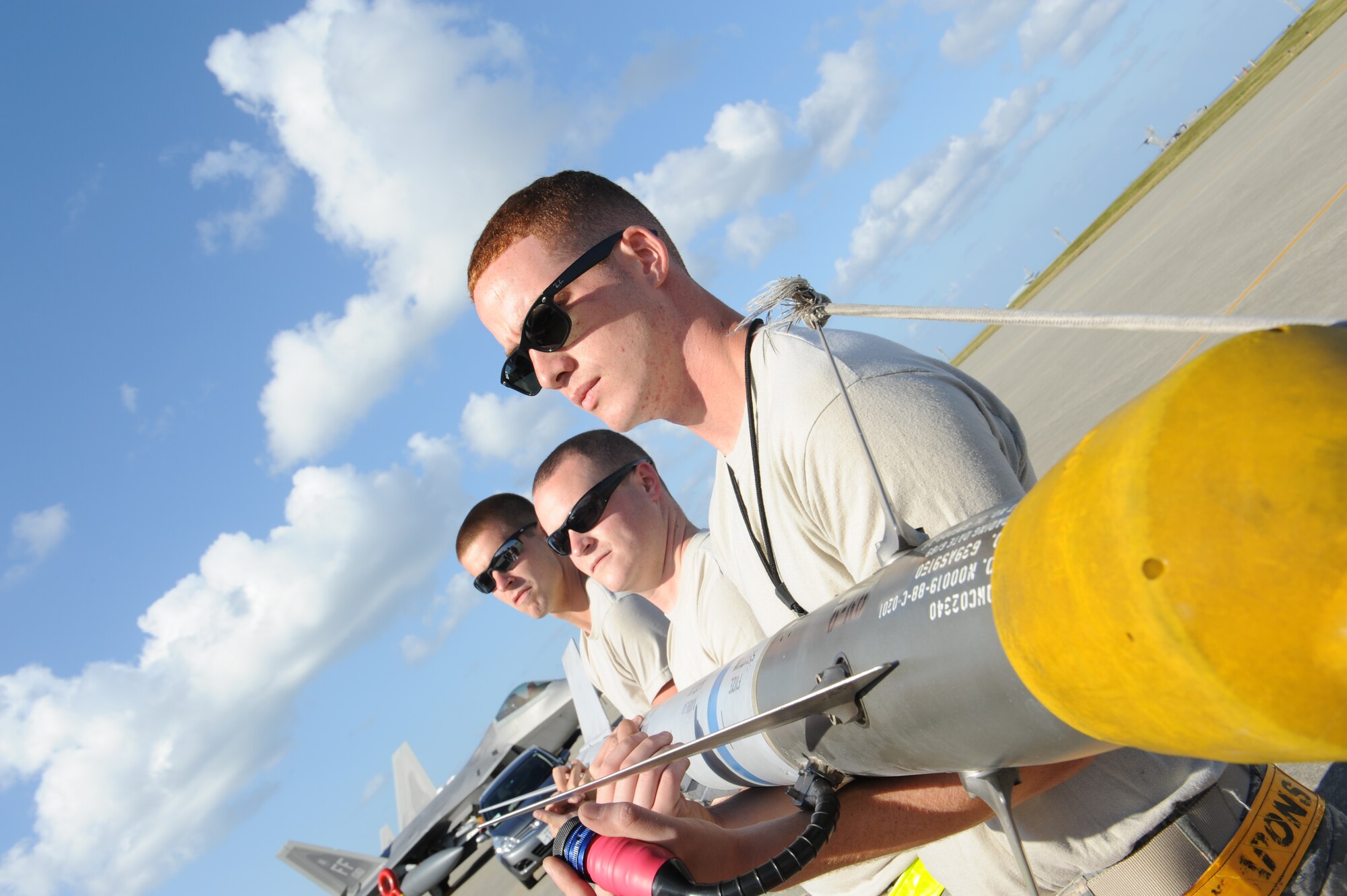 (Front to back) U.S. Air Force Airman 1st Class Donald Ransey, Staff Sgt. Brian McClellan and Airman 1st Class Jacob Yarber, 27th Fighter Squadron weapons load crew members and team chief, inspect an AIM-9 missile on prior to a F-22 Raptor training mission on Kadena Air Base, Japan, Oct. 4, 2012. (U.S. Air Force photo/Airman 1st Class Malia Jenkins)