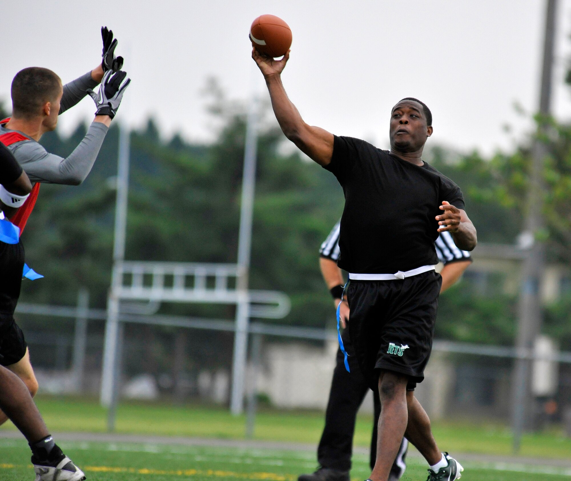 Douglas Brown, 35th Maintenance Squadron quarterback, releases the ball before defenders can disrupt the play at Misawa Air Base, Japan, Oct. 6, 2012. The 35 MXS battle against the Patrol Squadron 8 Tigers in a showdown that is sure to be a sneak-peak playoff matchup for later in the season. The 35 MXS  defeated the VP-8 Tigers in the closing seconds of the game 27 to 26. (U.S. Air Force photo by Airman 1st Class Zachary Kee)
