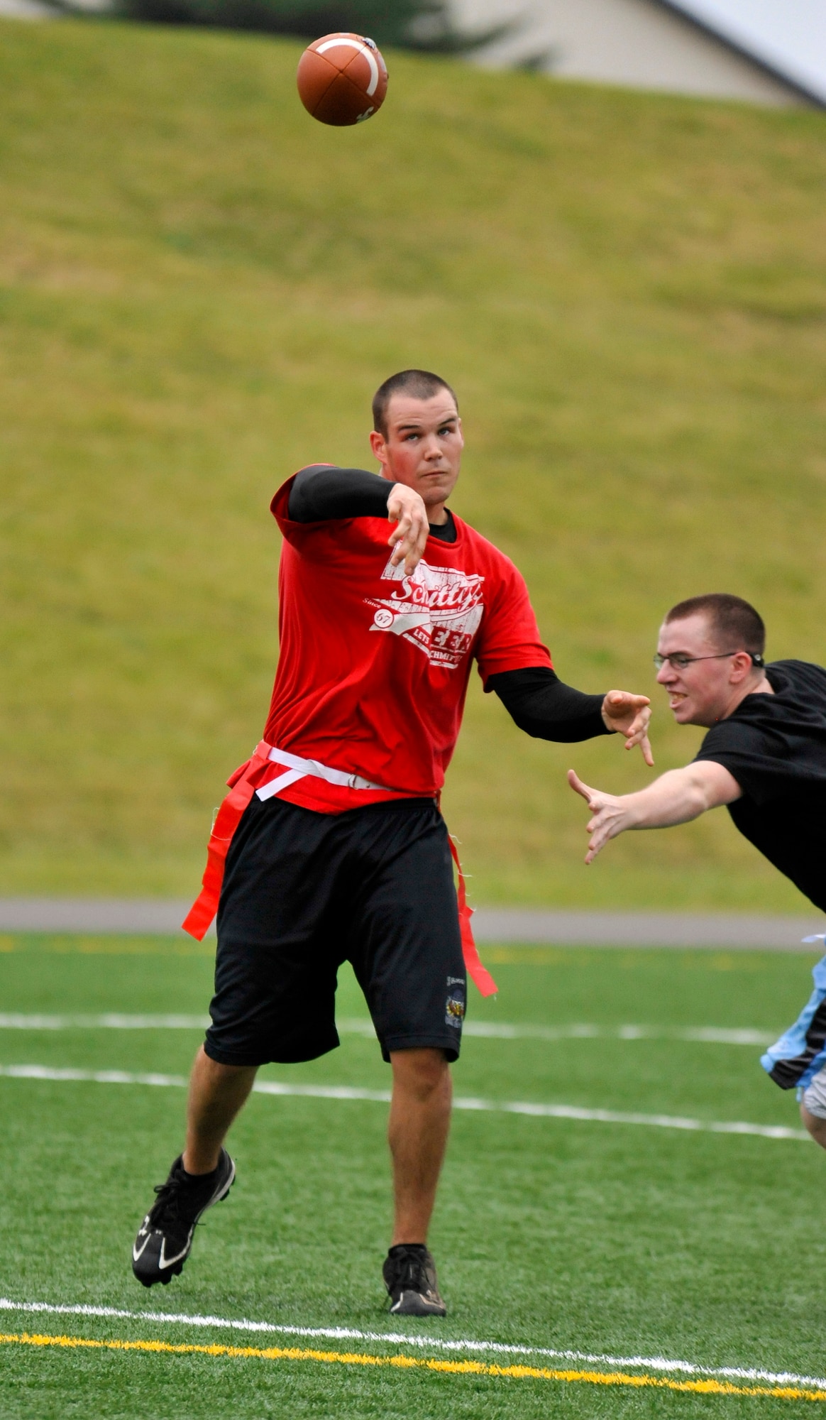 Michael George, 35th Medical Group quarterback, throws the ball downfield before a 35th Communications Squadron defender can pull his flag at Misawa Air Base, Japan, Oct. 6, 2012. The 35 MDG defeated the 35 CS to win their first game of the season 19 to 12. (U.S. Air Force photo by Airman 1st Class Zachary Kee)