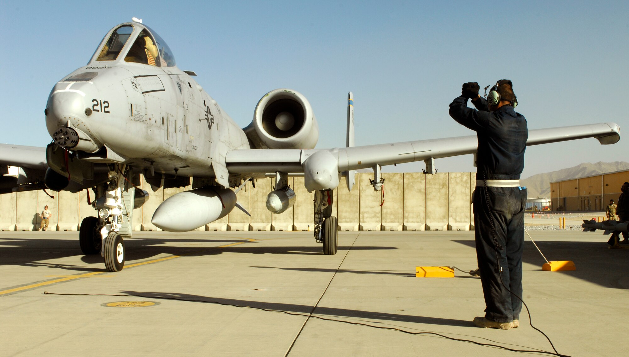 An aircraft maintainer from the 455th Expeditionary Aircraft Maintenance Squadron marshals a U.S. Air Force A-10 Thunderbolt II from Davis-Monthan Air Force Base’s 354th Fighter Squadron to its parking spot at Bagram Airfield, Afghanistan, Oct. 4, 2012. Affectionately called the ‘Warthog’, the A-10 is a specialized ground-attack aircraft which provides close air support to ground forces operating in Afghanistan. (U.S. Air Force photo/Staff Sgt. Jeff Nevison)